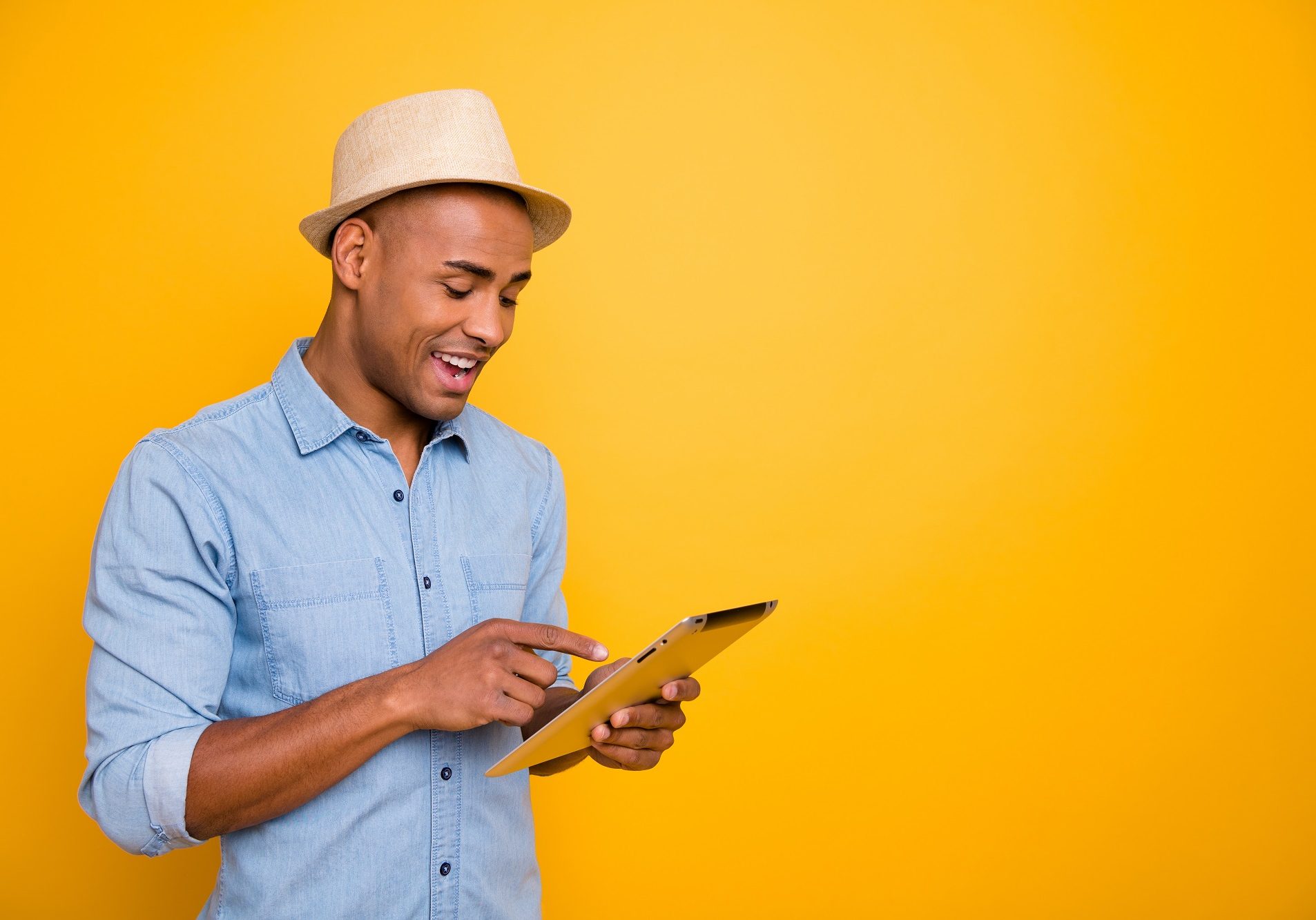 Proifile side photo of focused, cheerful youth use user device check voyage isolated over yellow background